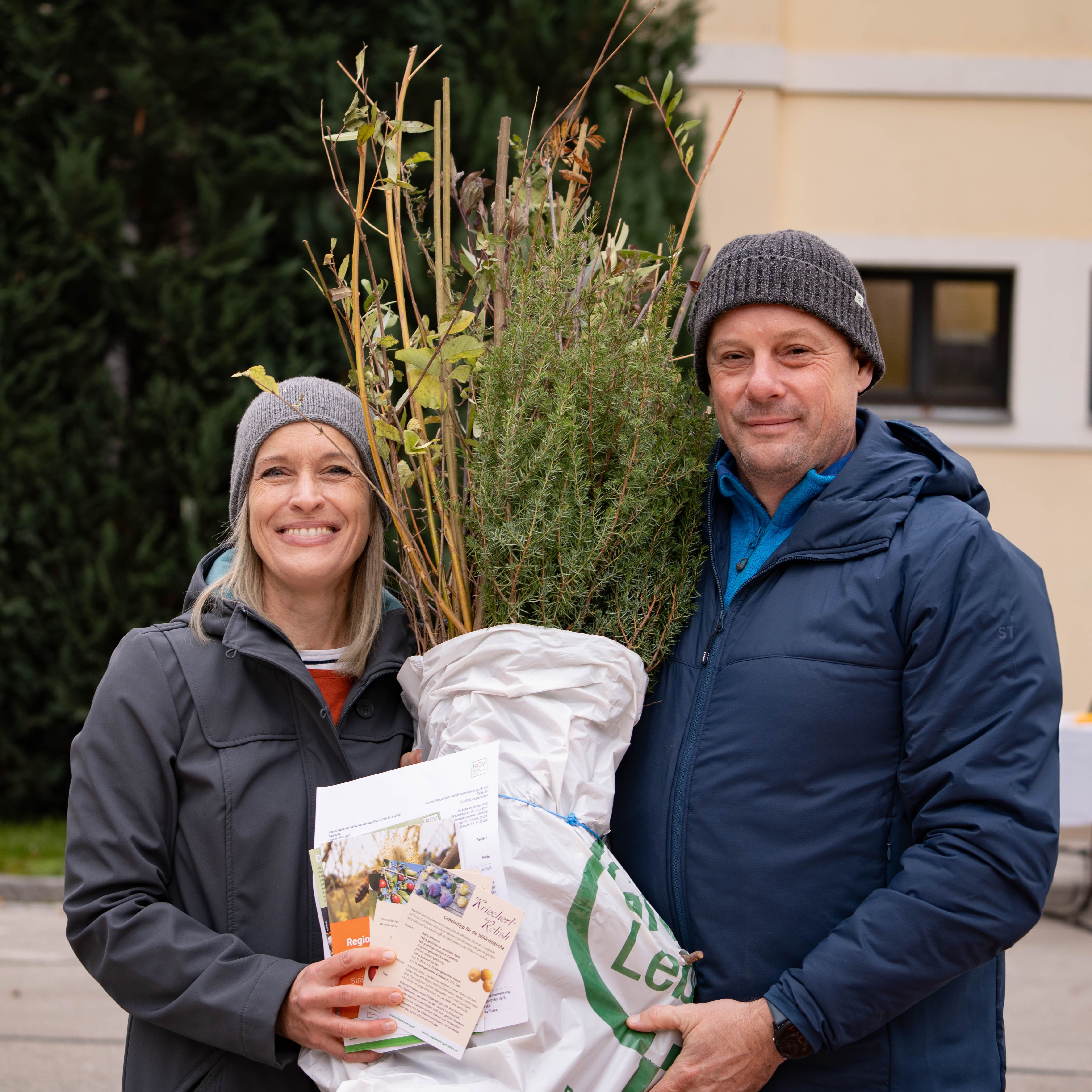 Zwei Personen mit einem Bündel heimischer Gehölze und Informationsmaterial zum NÖ Heckentag
