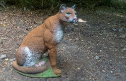 Naturgetreues 3D-Pumaziel mit braunem Fell und langem Schwanz in sitzender Haltung auf dem Waldboden
