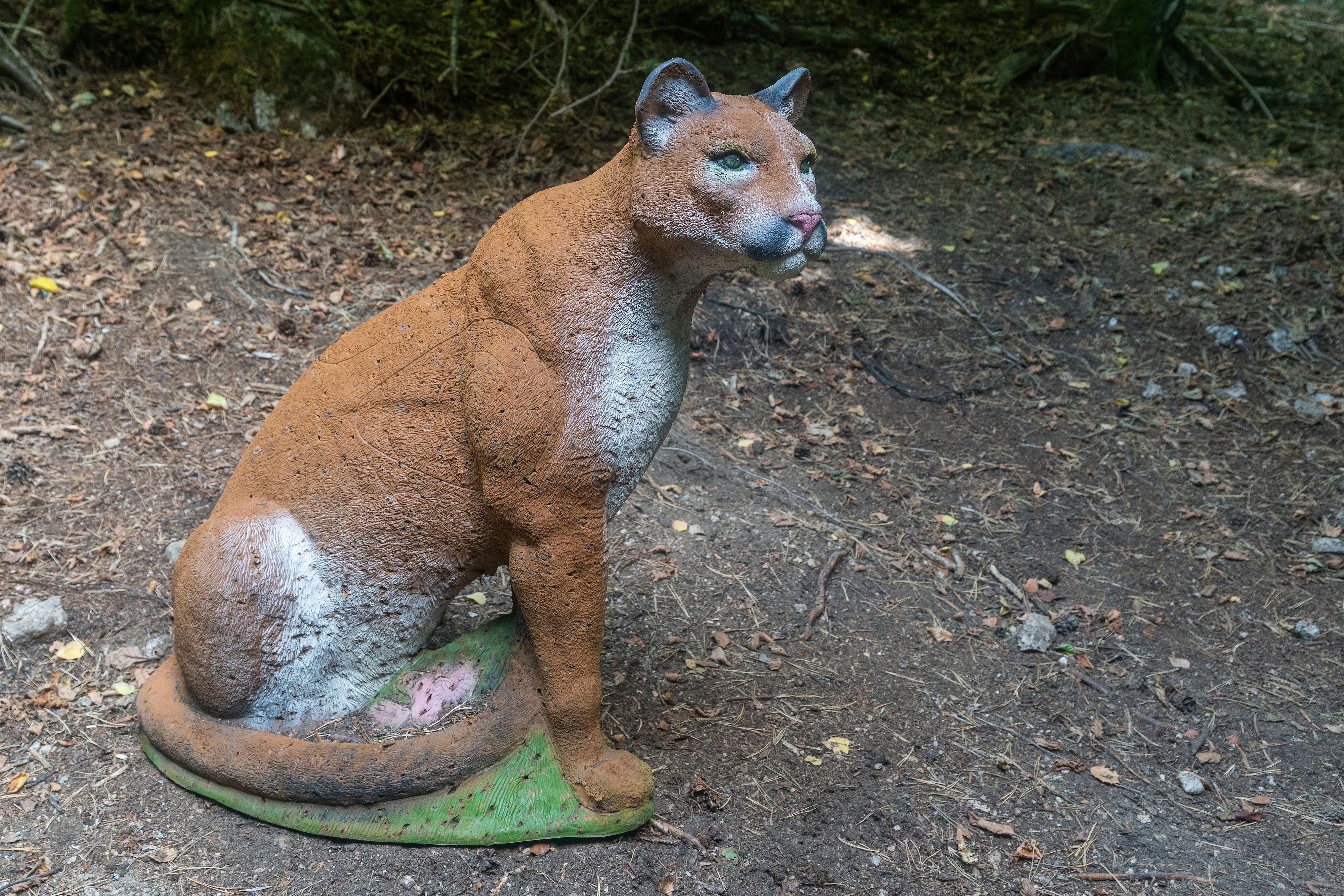 Naturgetreues 3D-Pumaziel mit braunem Fell und langem Schwanz in sitzender Haltung auf dem Waldboden