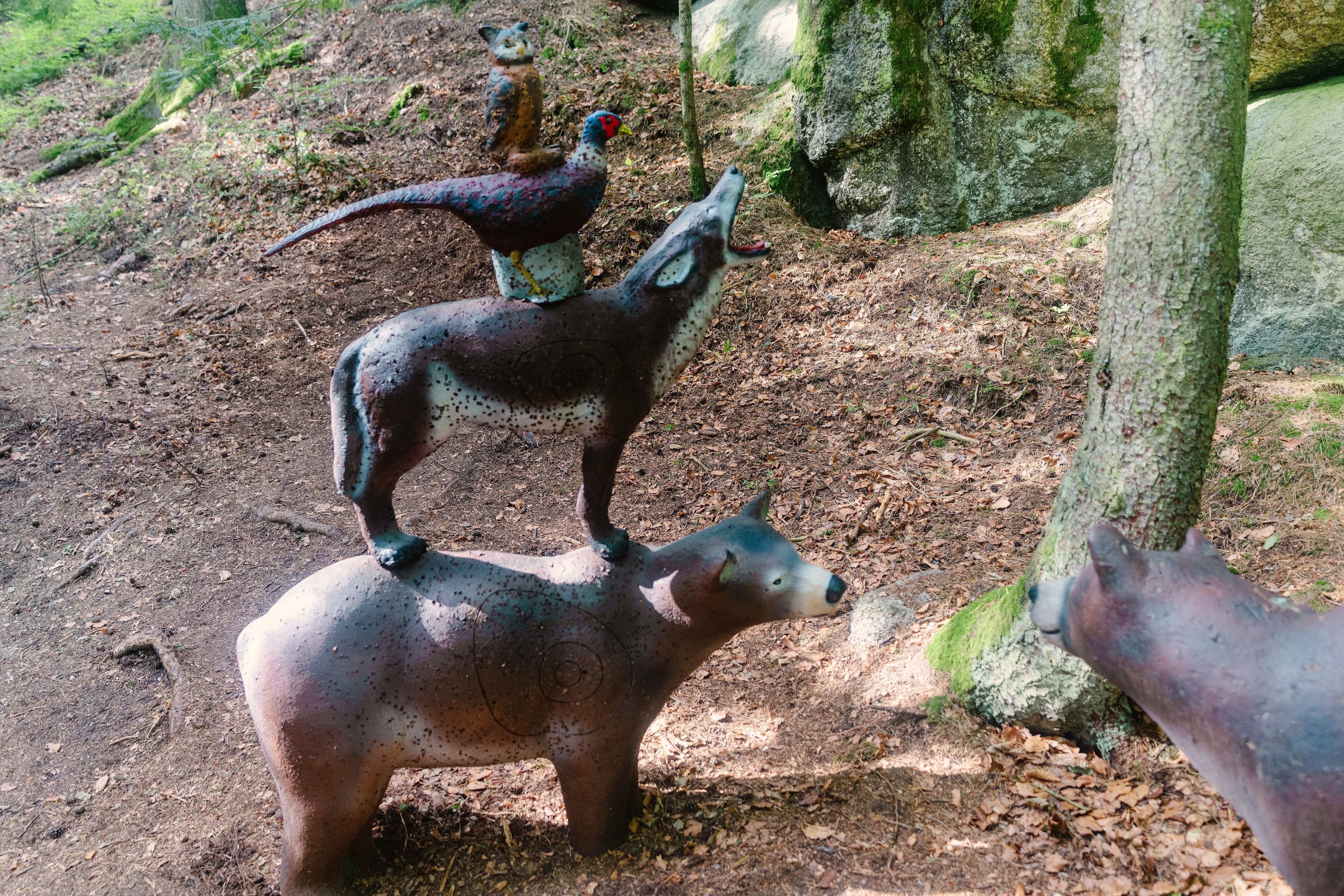 Übereinander angeordnete 3D-Tierziele mit zwei Bären, einem Wolf, einem Fasan und einer Eule im Wald