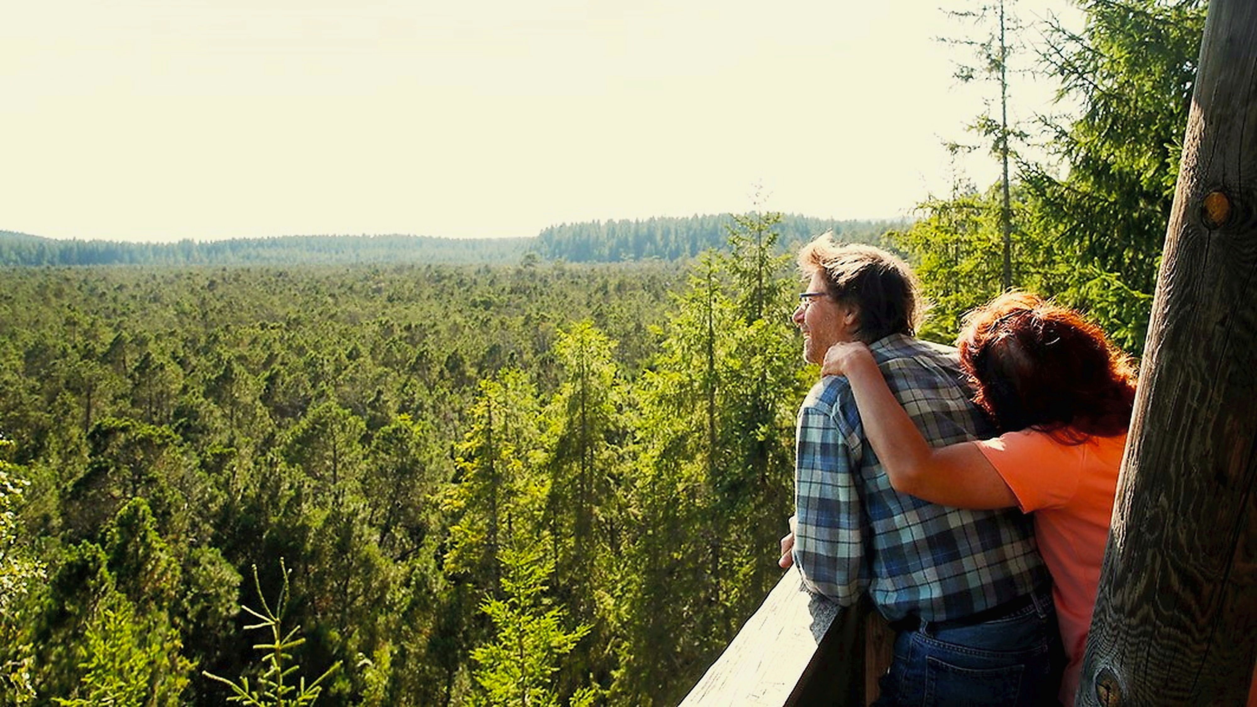 Zwei Personen genießen den Ausblick vom Aussichtsturm des Naturparks Nordwald in Richtung Große Haide